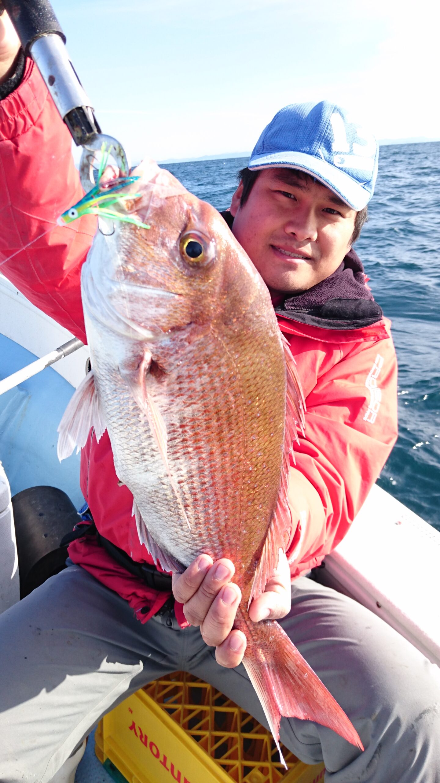 飛翔で釣り上げた大きなマダイを持つ釣り人